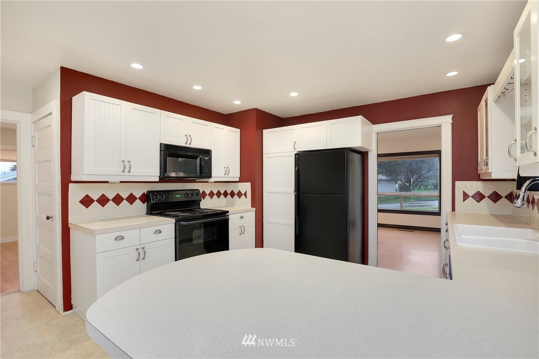 617 Reiten Road Kent, WA 98030 - Photo 6 of 30 a kitchen with stainless steel appliances kitchen island granite countertop a refrigerator a sink and a microwave