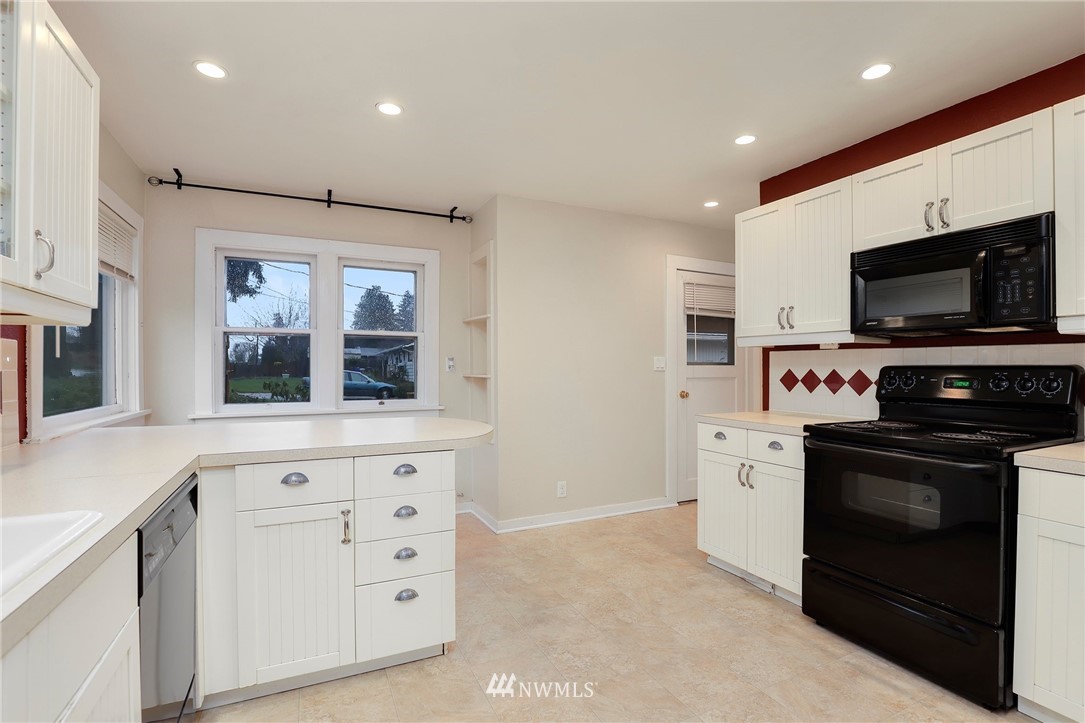617 Reiten Road Kent, WA 98030 - Photo 8 of 30 a kitchen with stainless steel appliances a stove microwave and sink
