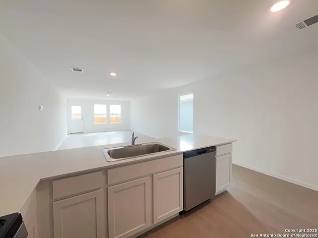 a kitchen with sink and mirror