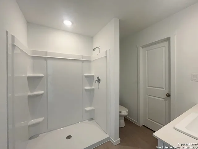 a bathroom with a shower a toilet and sink