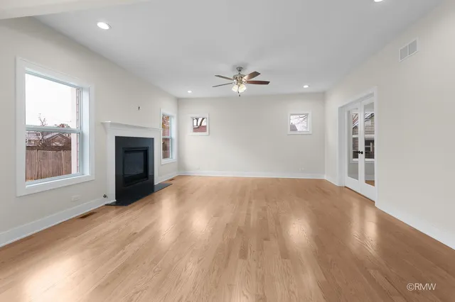 an empty room with windows and fireplace