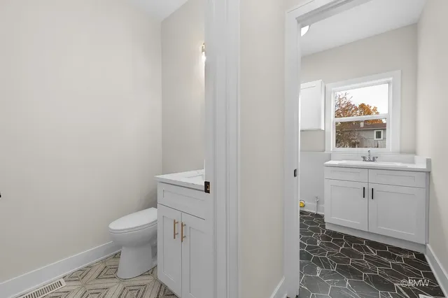 a bathroom with a sink toilet and window