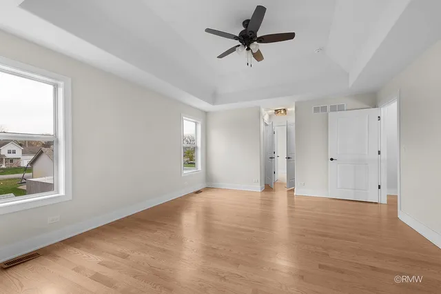 a view of empty room with wooden floor and window
