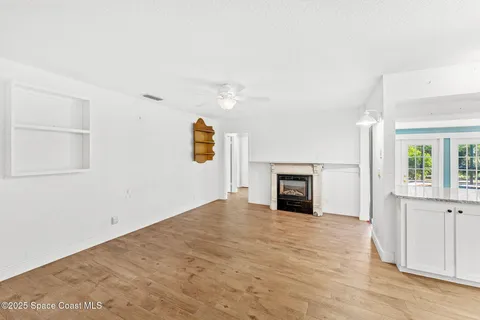 an empty room with windows and fireplace