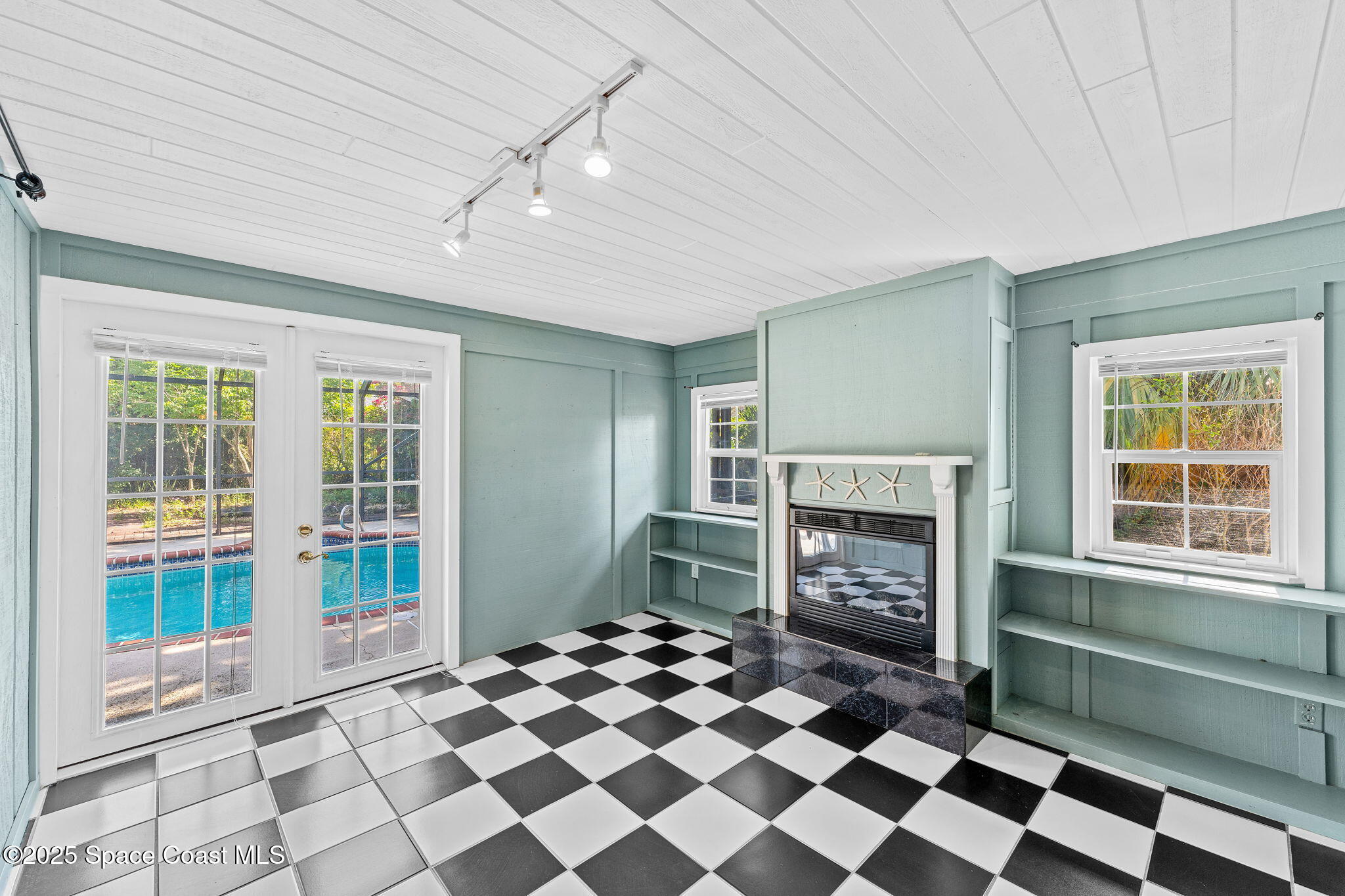 544 Solitaire Palm Drive Indialantic, FL 32903 - Photo 13 of 37 a room with a fireplace and a floor to ceiling window