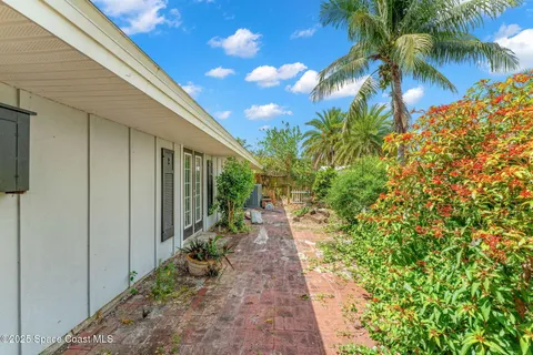 a backyard of a house with plants and outdoor seating