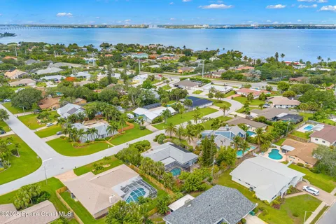 an aerial view of residential houses with outdoor space and ocean view