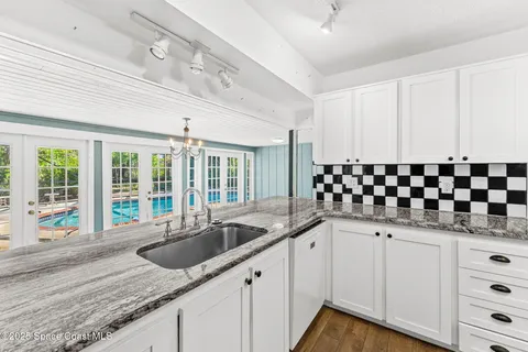 a kitchen with granite countertop a sink and cabinets