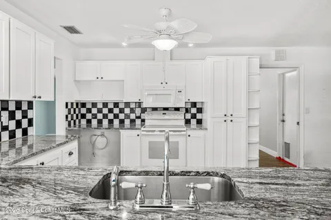 a kitchen with stainless steel appliances kitchen island granite countertop a sink and cabinets