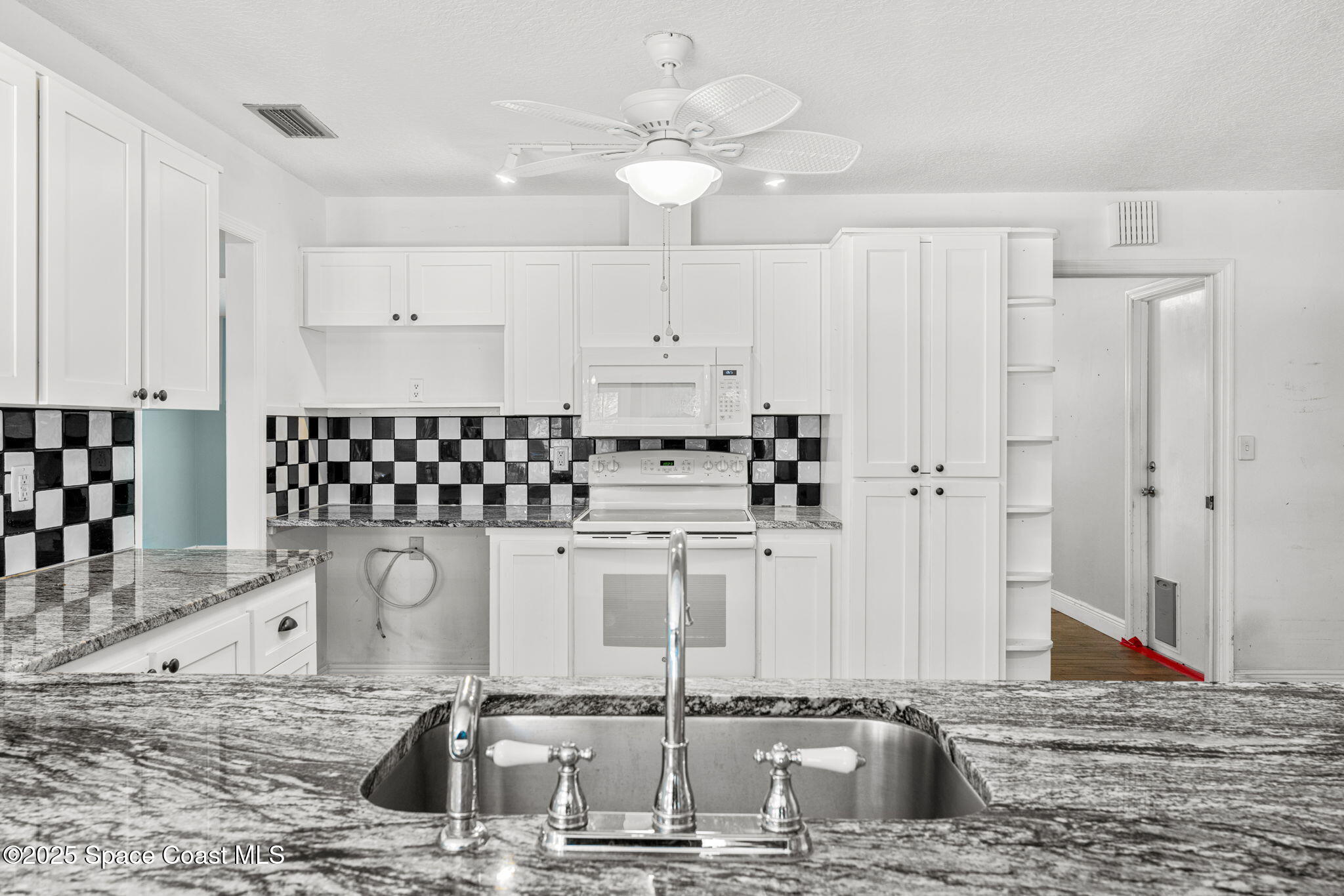 544 Solitaire Palm Drive Indialantic, FL 32903 - Photo 9 of 37 a kitchen with stainless steel appliances kitchen island granite countertop a sink and cabinets