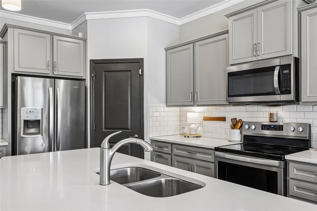 2575 Auburn Ridge Drive Apopka, FL 32712 - Photo 11 of 48 a kitchen with stainless steel appliances wooden cabinets a stove a sink and dishwasher