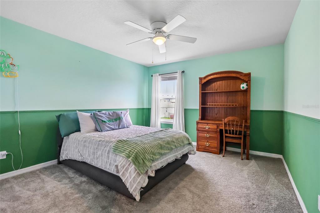 2575 Auburn Ridge Drive Apopka, FL 32712 - Photo 24 of 48 a bedroom with a bed a chandelier and dresser