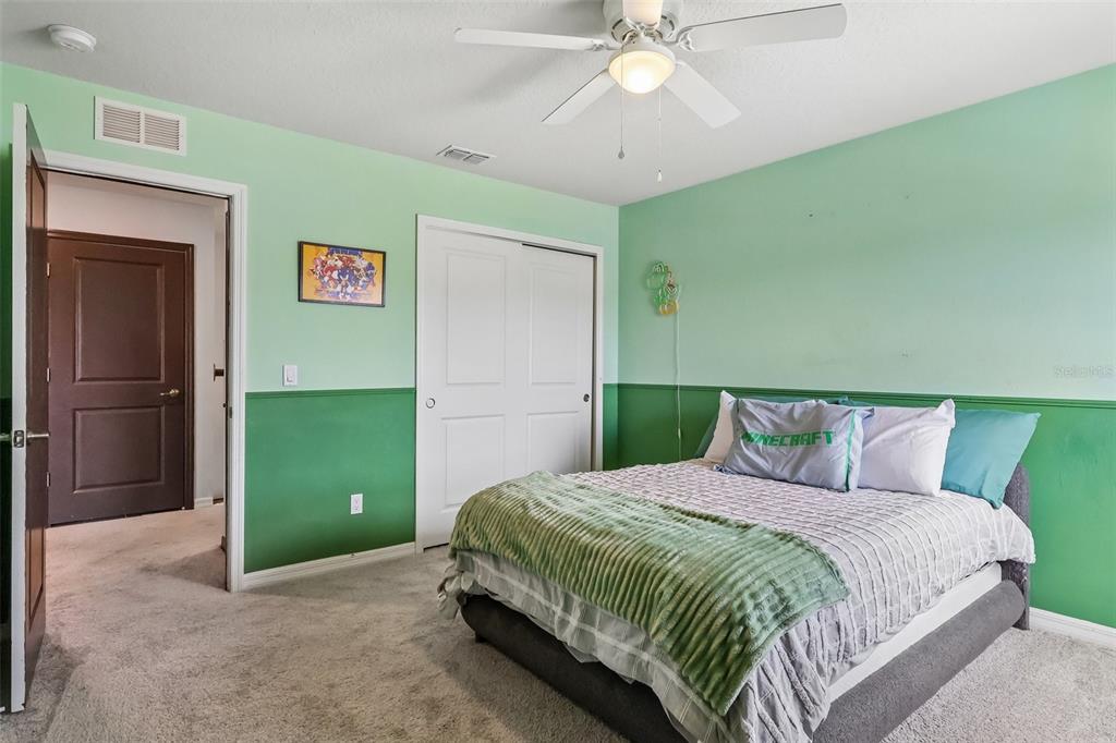 2575 Auburn Ridge Drive Apopka, FL 32712 - Photo 25 of 48 a spacious bedroom with a bed and a chandelier