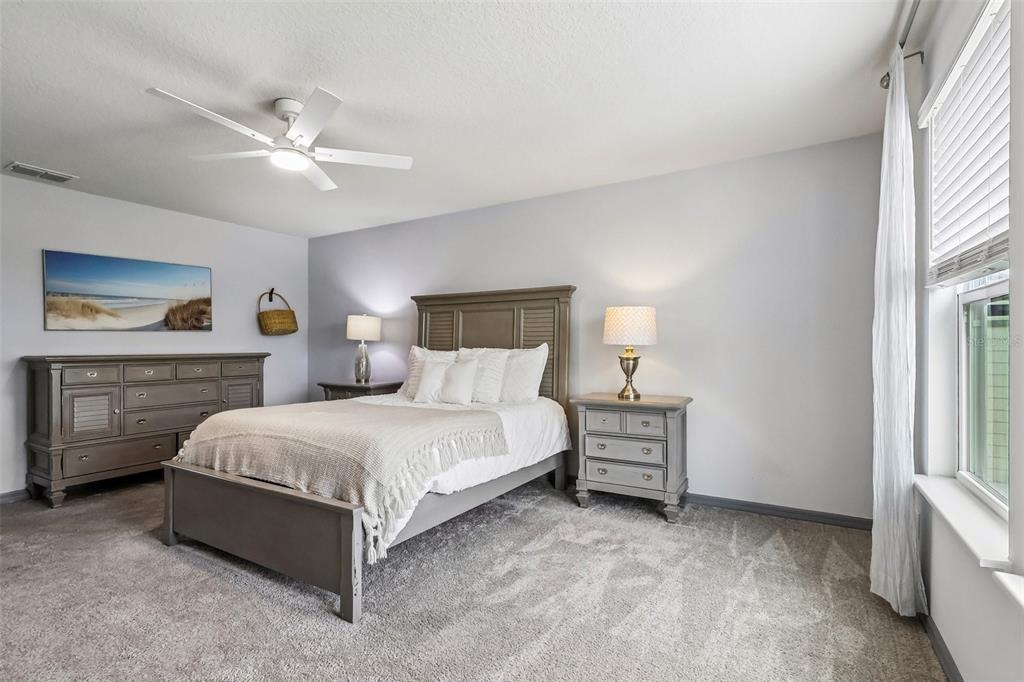 2575 Auburn Ridge Drive Apopka, FL 32712 - Photo 29 of 48 a spacious bedroom with a bed and a chandelier