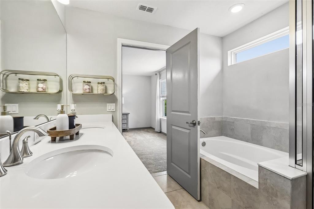 2575 Auburn Ridge Drive Apopka, FL 32712 - Photo 32 of 48 a bathroom with a tub sink and mirror