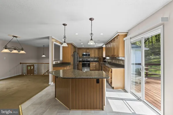 a kitchen with stainless steel appliances granite countertop a refrigerator and a stove top oven