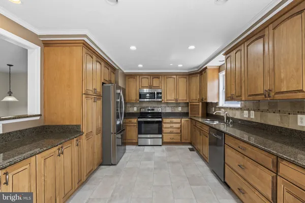 a kitchen with stainless steel appliances granite countertop a refrigerator and a stove top oven