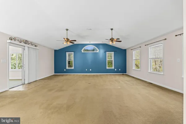 a view of an empty room with a fireplace and a window