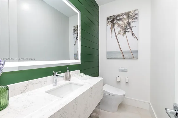 a bathroom with a sink a toilet and a mirror