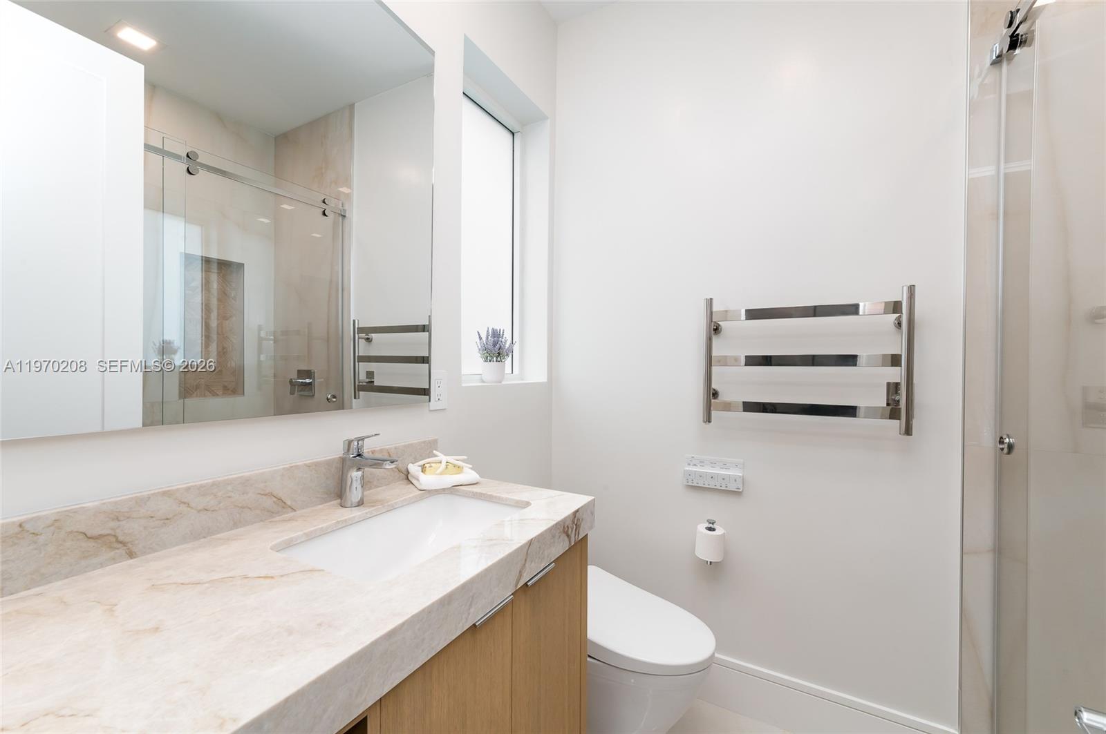 3740 Northeast 29th Avenue Lighthouse Point, FL 33064 - Photo 21 of 50 a bathroom with a sink a toilet and a mirror