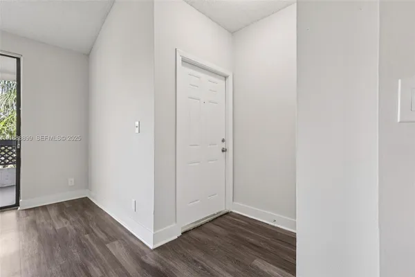 a view of an empty room with wooden floor