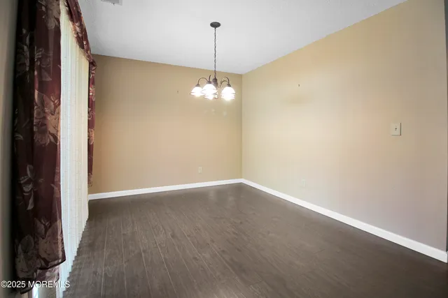 a view of a room with wooden floor and chandelier