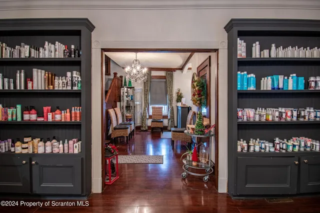 a living room with lots of books and a painting on the wall