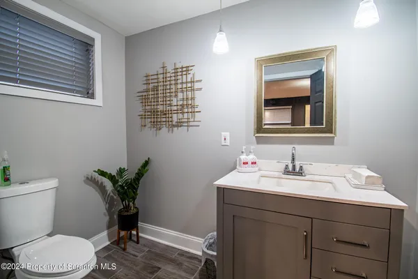 a bathroom with a toilet a sink and mirror