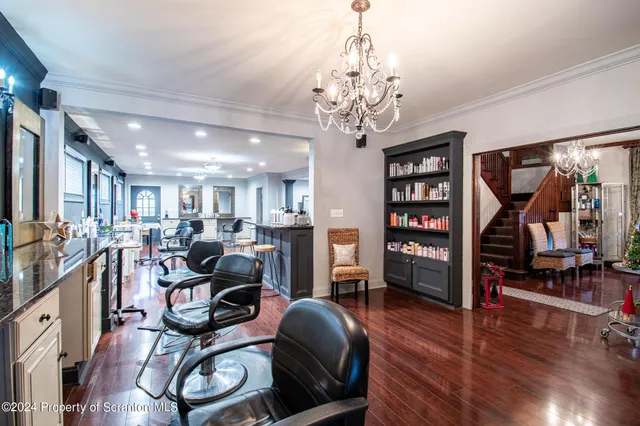 a living room with furniture a chandelier and wooden floor
