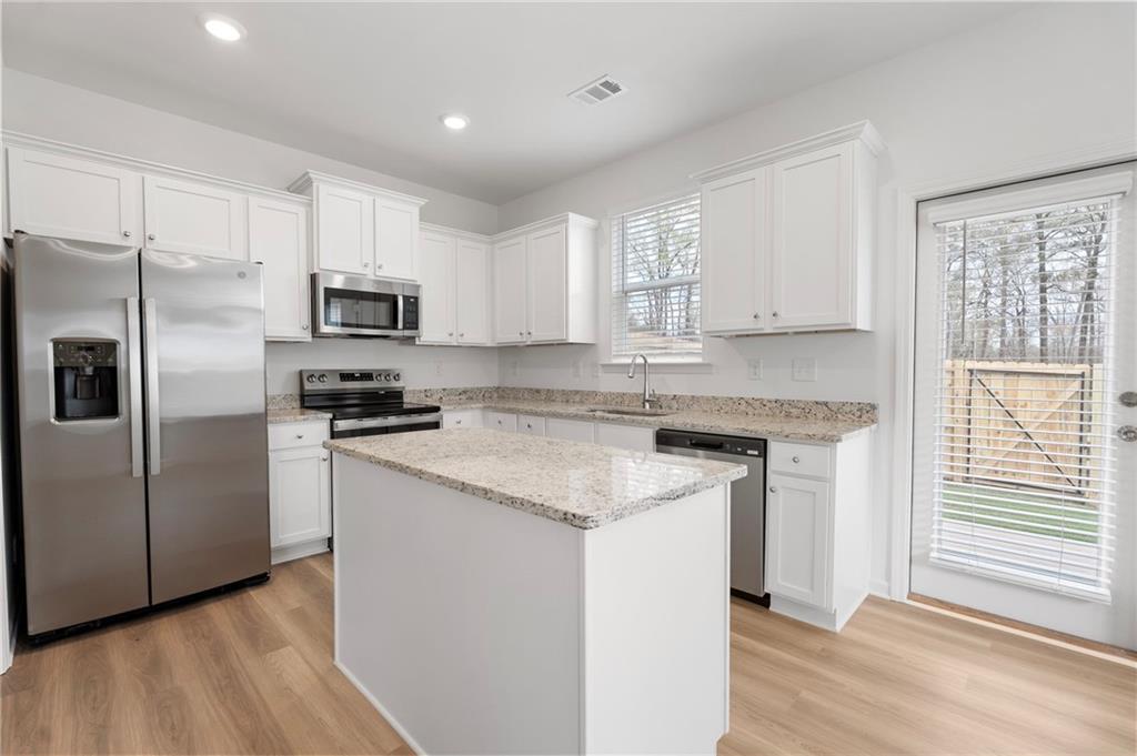 1532 Aralynn Way Conyers, GA 30013 - Photo 1 of 1 a kitchen with stainless steel appliances granite countertop a stove a sink and a refrigerator