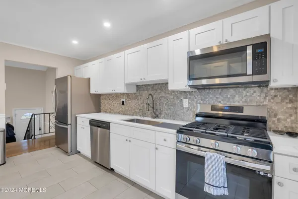 a kitchen with cabinets stainless steel appliances and a counter space