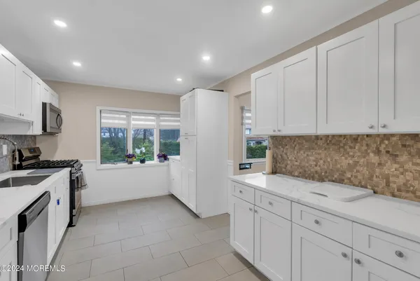 a kitchen with white cabinets and white appliances