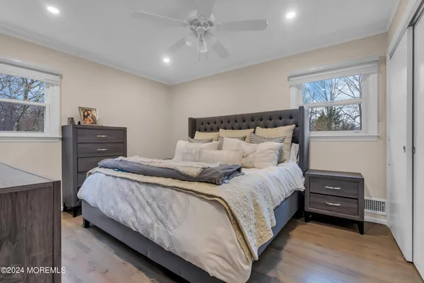 a bedroom with bed and wooden floor