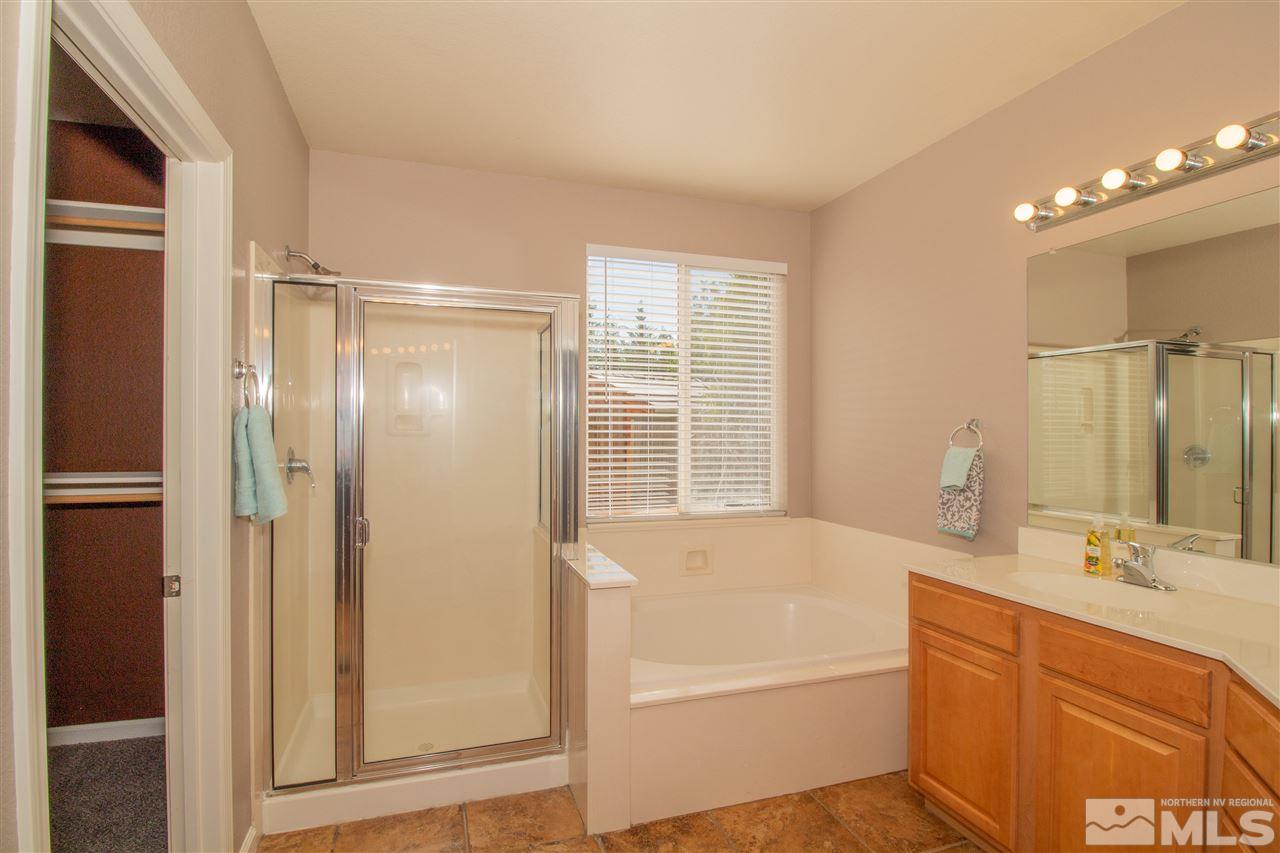 10030 Stonechase Court Reno, NV 89521 - Photo 11 of 24 a bathroom with a tub sink shower and a mirror