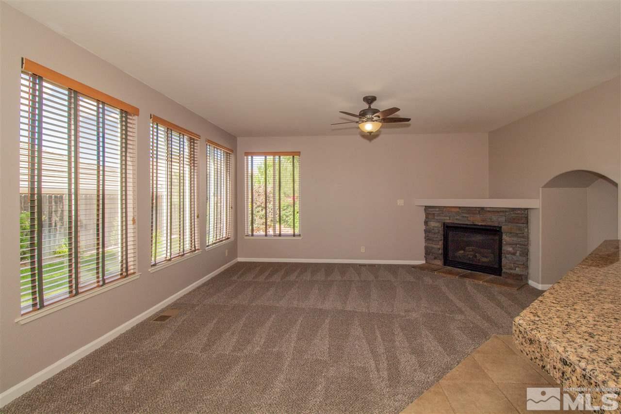10030 Stonechase Court Reno, NV 89521 - Photo 8 of 24 a view of an empty room with a fireplace and a window