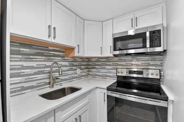 a kitchen with stainless steel appliances a stove sink and microwave
