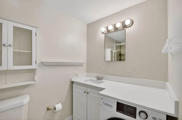 a bathroom with a sink a toilet and a mirror