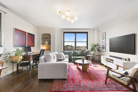 a living room with furniture flat screen tv and a large window