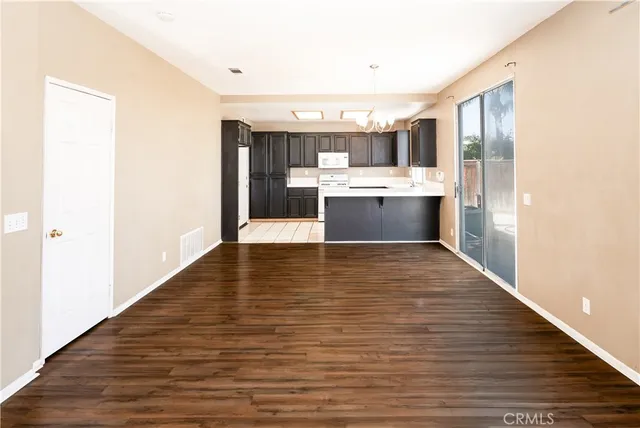 a view of a kitchen with kitchen island a sink wooden floor and a counter top space