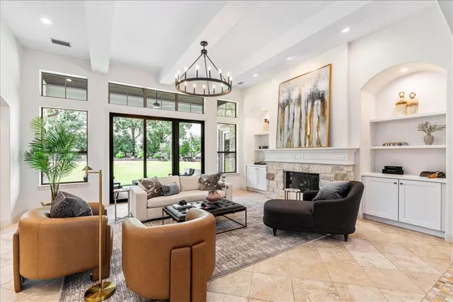 a living room with furniture a chandelier a fireplace and a chandelier