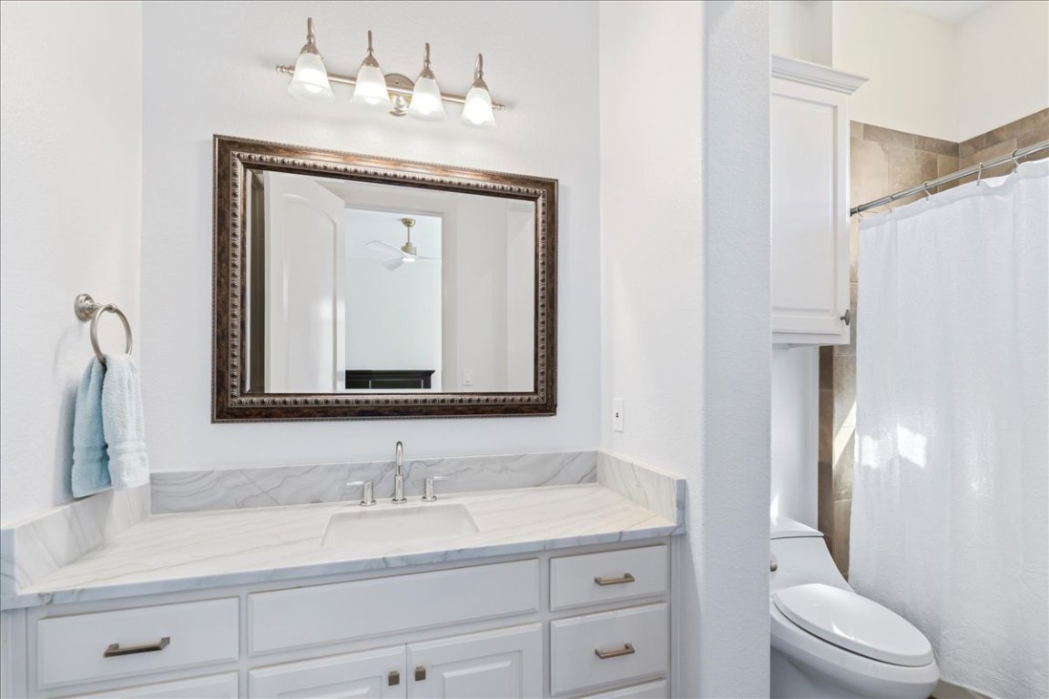 213 Black Wolf Run Austin, TX 78738 - Photo 16 of 39 a bathroom with a toilet sink and mirror