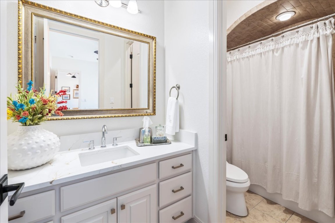 213 Black Wolf Run Austin, TX 78738 - Photo 20 of 39 a bathroom with a sink a toilet and a mirror