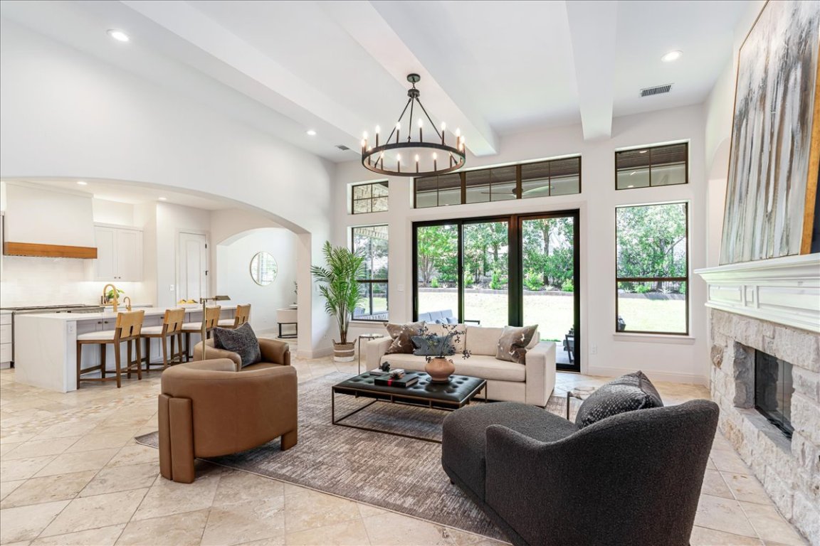 213 Black Wolf Run Austin, TX 78738 - Photo 2 of 39 a living room with furniture a fireplace and large windows