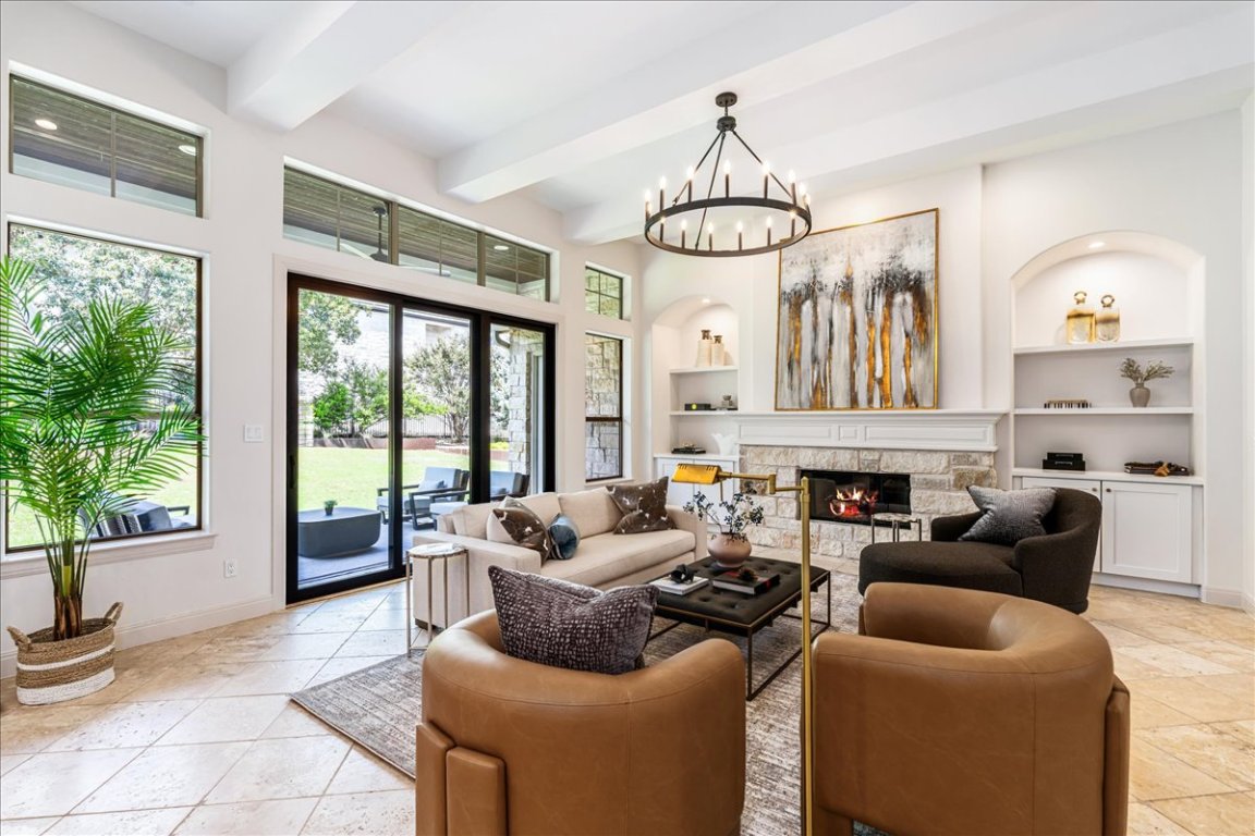 213 Black Wolf Run Austin, TX 78738 - Photo 3 of 39 a living room with furniture a chandelier and a fireplace