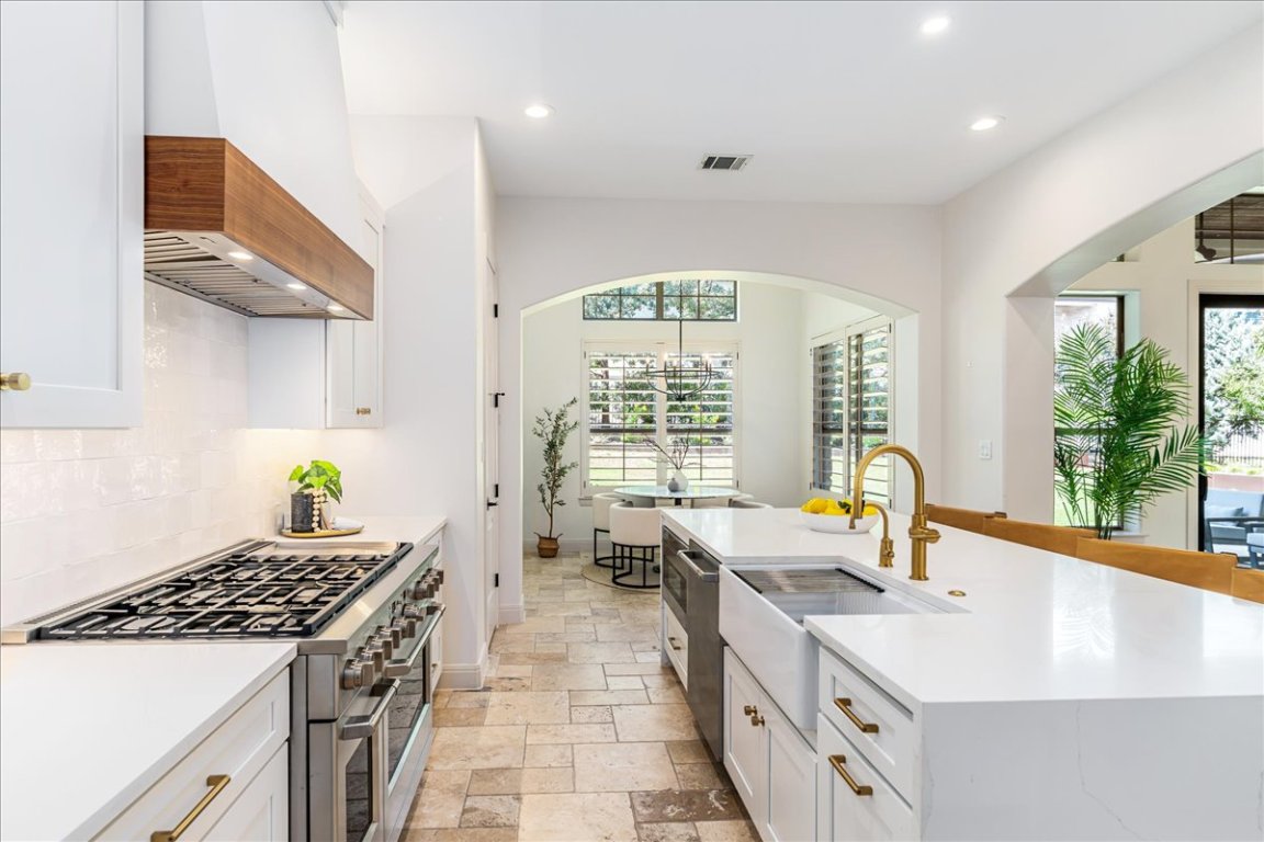 213 Black Wolf Run Austin, TX 78738 - Photo 6 of 39 a kitchen with a stove a sink a counter top space and living room view