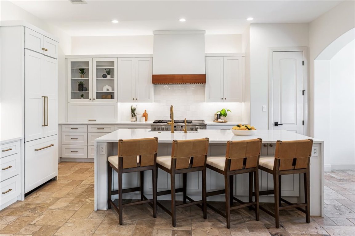 213 Black Wolf Run Austin, TX 78738 - Photo 7 of 39 a kitchen with stainless steel appliances kitchen island granite countertop a table chairs sink and cabinets