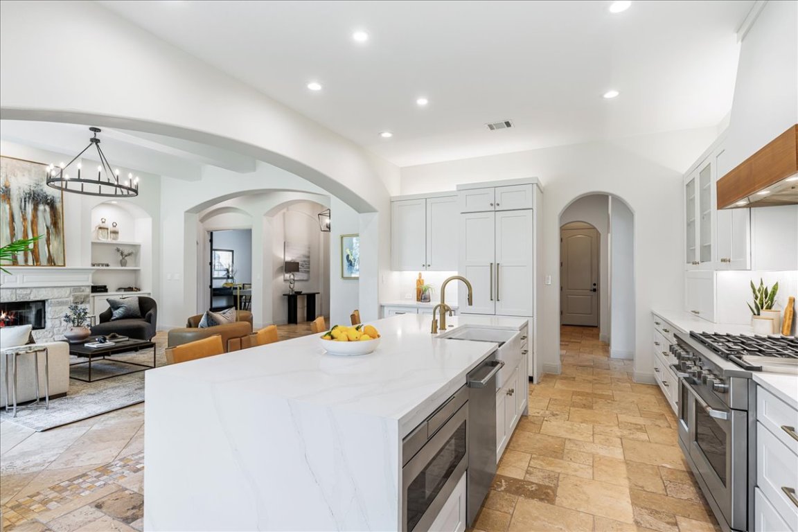 213 Black Wolf Run Austin, TX 78738 - Photo 8 of 39 a large white kitchen with sink a refrigerator and wooden cabinets