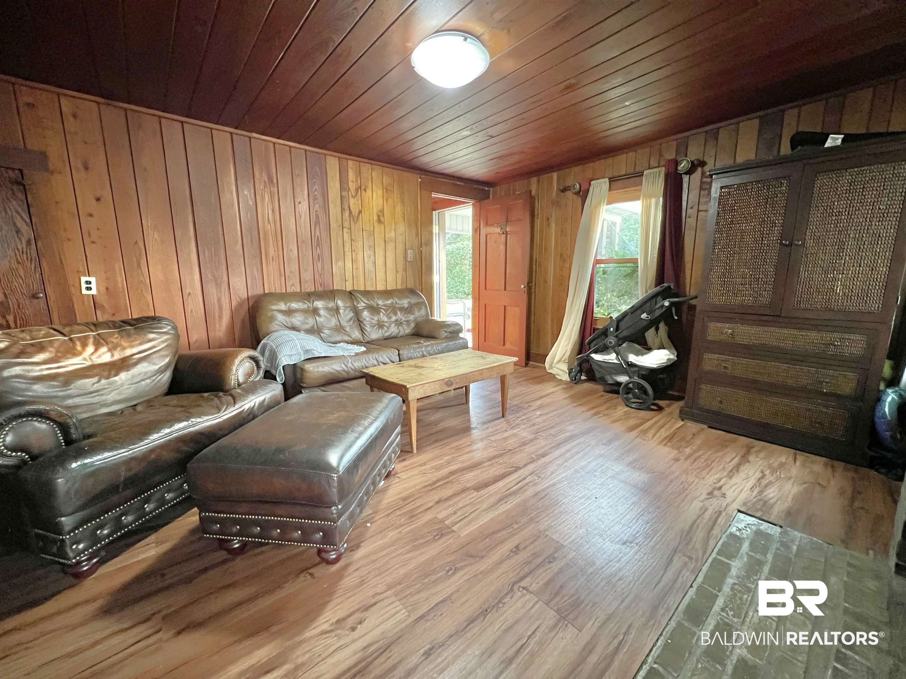 10283 Appleton Road Brewton, AL 36426 - Photo 7 of 18 Living room featuring light hardwood / wood-style flooring, wood walls, and wood ceiling