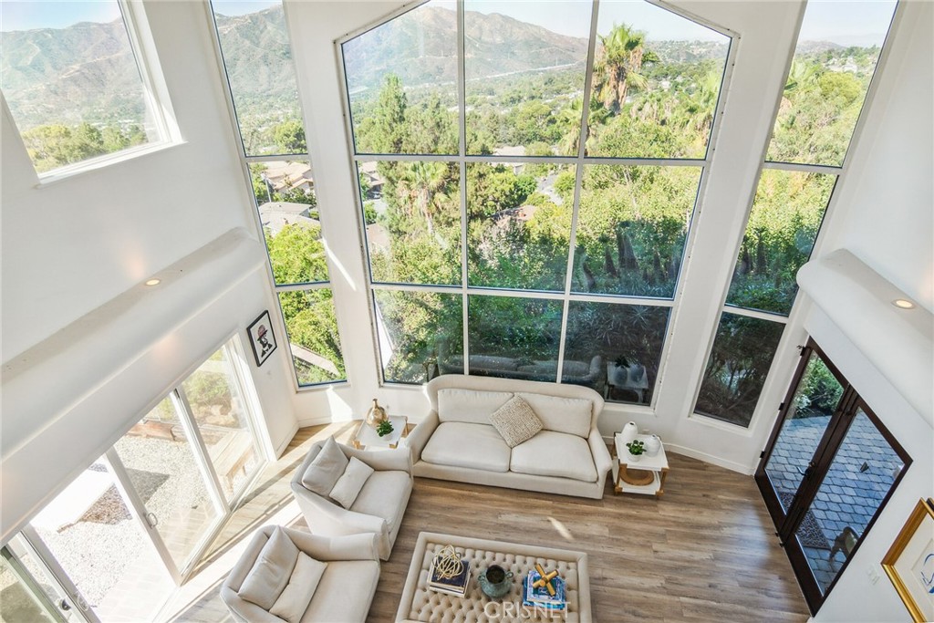 a living room with large windows and a table