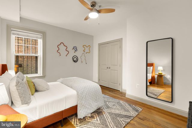 a spacious bedroom with a bed and wooden floor